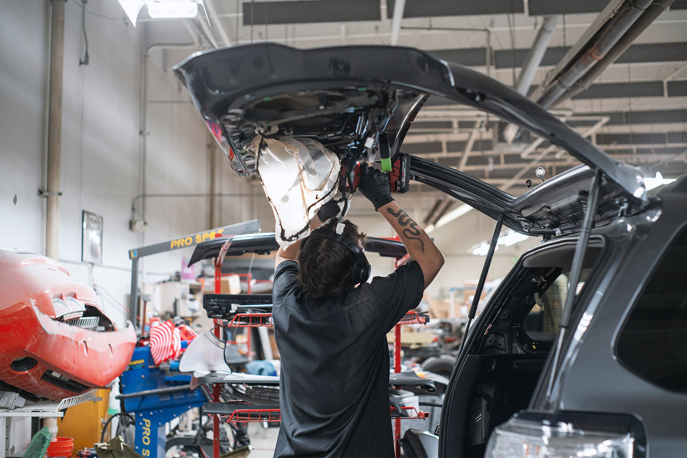 Subaru service member replacing the hood of a vehicle